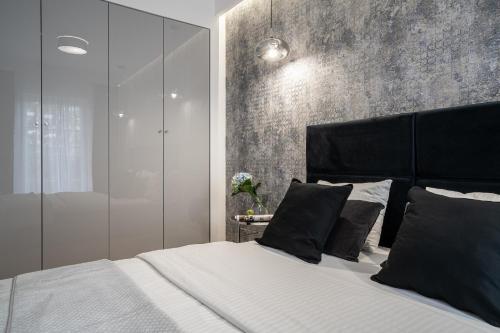 a bedroom with a large bed with a black headboard at AboutArtApartments - By the river in Wrocław