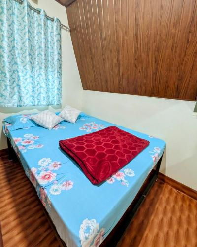 a bed with a red blanket on top of it at Coorgology - The estate stay in Madikeri