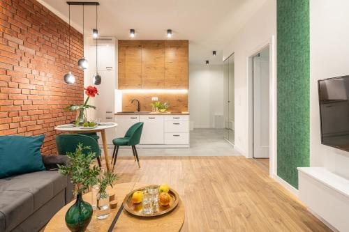 a living room and kitchen with a brick wall at AboutArtApartments - By the river in Wrocław