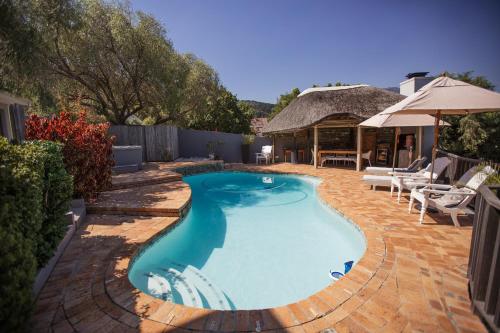 a swimming pool in the middle of a yard at Chapman's Peak Bed and Breakfast in Hout Bay