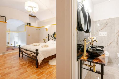 un dormitorio con una cama y un baño en Art of Living, Elegante casa nel centro storico, en LʼAquila