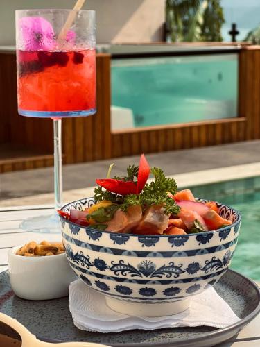 a bowl of food on a table with a drink at Catalina Hotel in Ubatuba