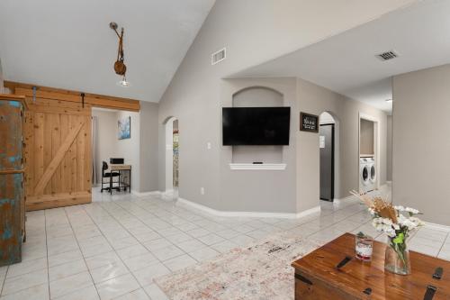 a living room with a flat screen tv on a wall at Modern rustic home in Olmito