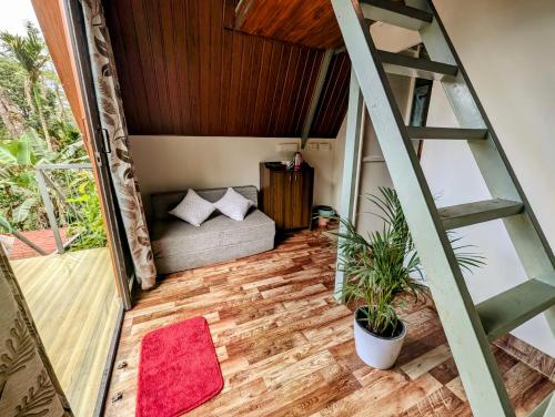 a living room with a couch and a ladder at Coorgology - The estate stay in Madikeri