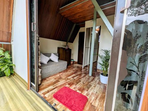 a living room with a couch and a red rug at Coorgology - The estate stay in Madikeri