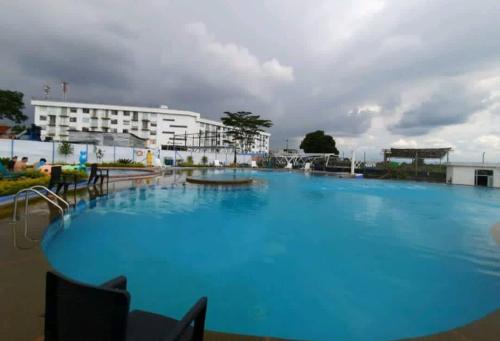 a large blue swimming pool in front of a building at Apartamento cerca al parque del cafe in Montenegro