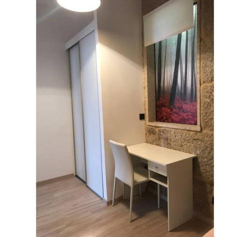 un escritorio con una silla y una pintura en la pared en Piso con vistas a 30m playa ALOJAMIENTOS VACAY, en Bueu