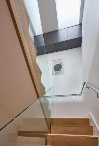 a staircase with glass railing and a skylight at Finlays Yard by Veeve in Manchester