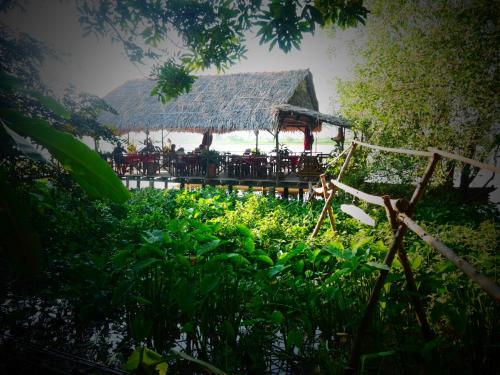 a restaurant with a straw roof on the beach at Happy Family Guesthouse in Vĩnh Long