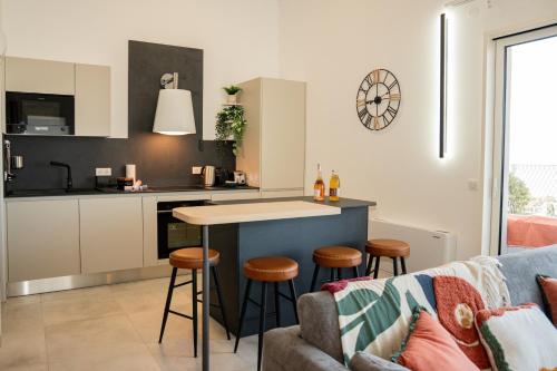 - une cuisine et un salon avec une table et des tabourets dans l'établissement Duplex T5 vue etang, terrasse & suite parentale, à Sète