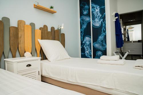 - 2 lits dans une chambre avec des planches de surf sur le mur dans l'établissement Duplex T5 vue etang, terrasse & suite parentale, à Sète