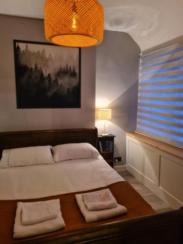 a bedroom with a bed with two towels on it at Peebles High Street Apartment in Peebles