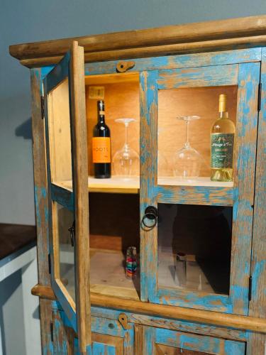 a wooden cabinet with wine bottles and glasses at Modern rustic home in Olmito