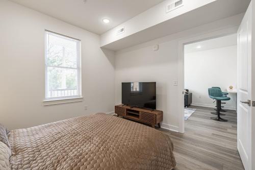 a bedroom with a bed and a flat screen tv at Belle Isle Apt - TH06 - Tourist Homes of Richmond in Richmond