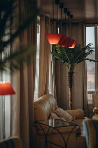 a living room with a chair and a palm tree at Hotel Polamar in Santa Pola