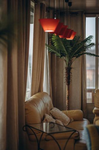 a living room with a chair and a palm tree at Hotel Polamar in Santa Pola
