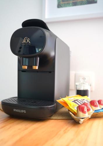 a coffee maker sitting on top of a table with food at Studio Hibis Blue in Cayenne