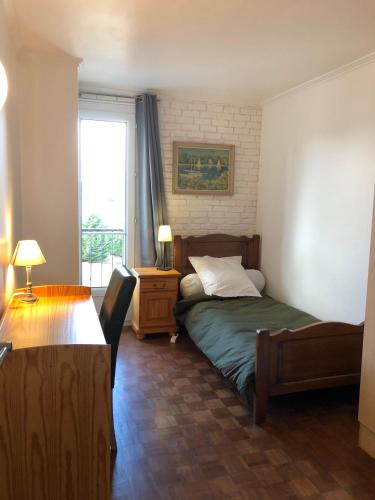une chambre avec un lit, une table et une fenêtre dans l'établissement Bel appartement centre Saint Brieuc a pied, à Saint-Brieuc