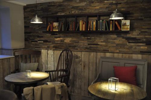 2 tables et des chaises dans un restaurant avec des livres dans l'établissement Higher Buck Inn, à Waddington