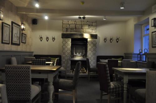 a restaurant with tables and chairs and a fireplace at Higher Buck Inn in Waddington