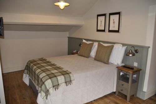 a bedroom with a bed and a side table at Higher Buck Inn in Waddington