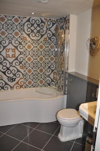 a bathroom with a tub and a toilet and a shower at Higher Buck Inn in Waddington