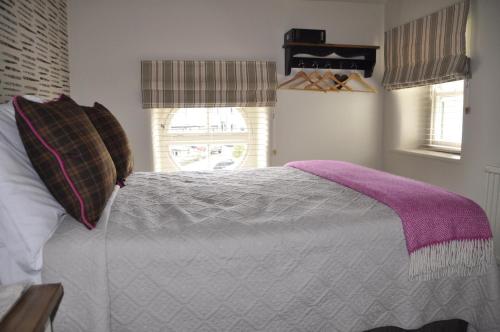 a bedroom with a bed with a purple blanket at Higher Buck Inn in Waddington