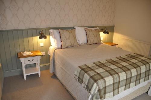 a bedroom with a bed and a side table at Higher Buck Inn in Waddington