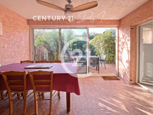 une salle à manger avec une table et des chaises et une grande fenêtre dans l'établissement Maison avec jardin proche de la plage, à Calvi