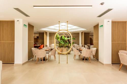 a dining room with a round mirror and chairs at Hotel El Tujjar in Los Barrios