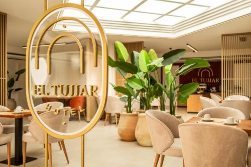 a mirror in a restaurant with chairs and plants at Hotel El Tujjar in Los Barrios