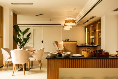 a kitchen with chairs and a table with bowls on it at Hotel El Tujjar in Los Barrios