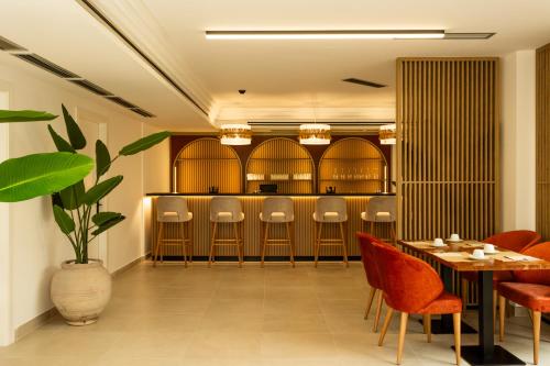 a restaurant with a bar with chairs and a table at Hotel El Tujjar in Los Barrios