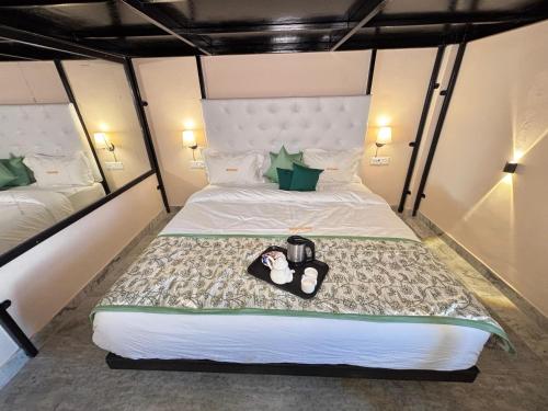 a bedroom with a bed with two shoes on it at Hotel Nirvana Lakeside in Udaipur