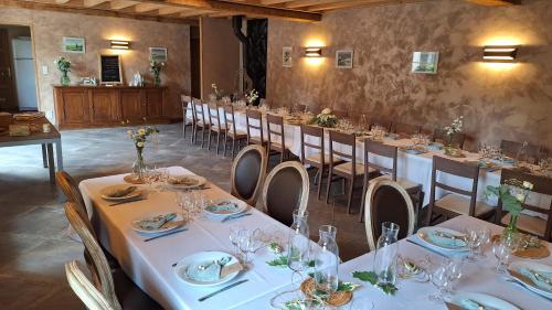 a dining room with tables and chairs with white linens at Au Puy Des Vérités in Lapalisse