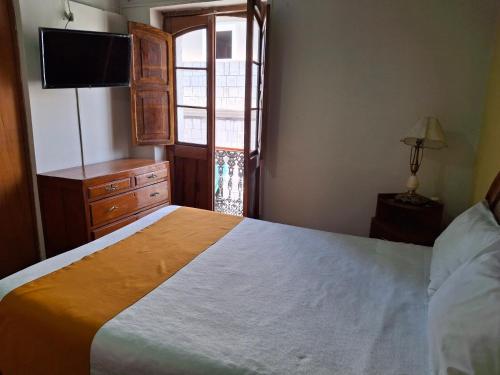 Ένα ή περισσότερα κρεβάτια σε δωμάτιο στο Hostal Lluvia de Oro