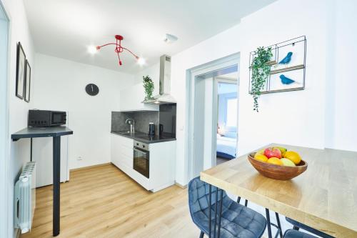 une cuisine avec une table avec un bol de fruits dessus dans l'établissement BE-3D - Appartement F3 pour 1-4 pers au 3ème étage au centre de Mulhouse, à Mulhouse
