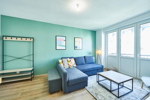 un salon avec un canapé bleu et une table dans l'établissement BE-3D - Appartement F3 pour 1-4 pers au 3ème étage au centre de Mulhouse, à Mulhouse