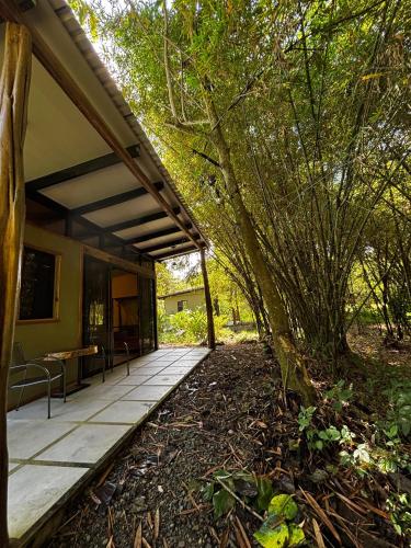 a porch of a house with a table and chairs at Bamboo River Lodge in Horquetas