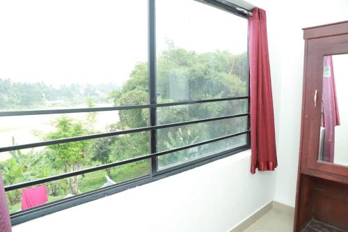 a window with a view of the forest at Royal Park in Wayanad