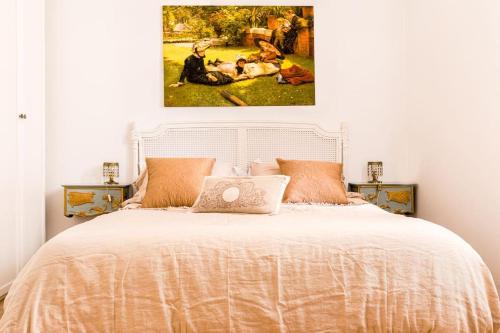 a bedroom with a bed with a painting on the wall at NINA'S HOUSE - Monti Residences in Rome