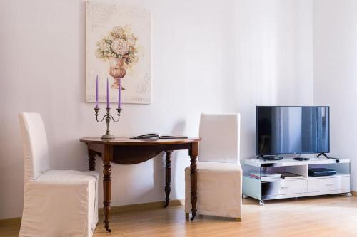a room with a table with two chairs and a tv at NINA'S HOUSE - Monti Residences in Rome