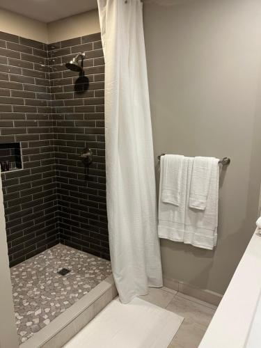 a bathroom with a shower with a black tiled wall at The Palms in Belize City