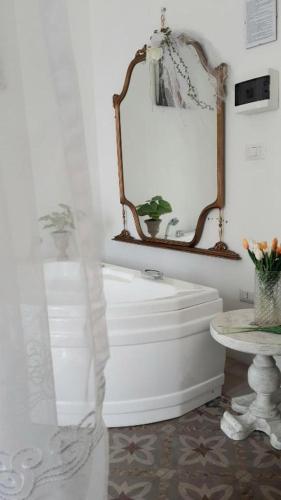 a bathroom with a white tub and a mirror at Morosoli Spa in Catania