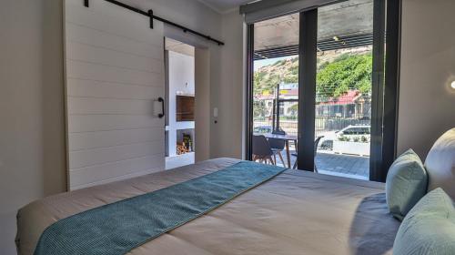 Un dormitorio con una cama y una ventana grande. en 109 Mossel Cove Home away from Home, en Mossel Bay