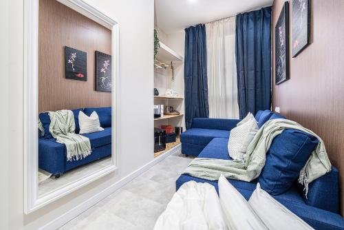 a living room with a blue couch and a mirror at Rooms Canteras Boutique Hostal in Las Palmas de Gran Canaria