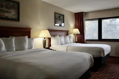 une chambre d'hôtel avec deux lits et une fenêtre dans l'établissement Carlton Lodge Hotel and Suites, à Adrian
