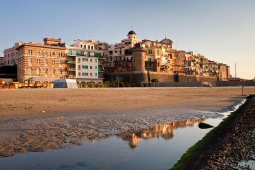 a group of buildings on a beach with a body of water at Ambramarina B&B in Nettuno