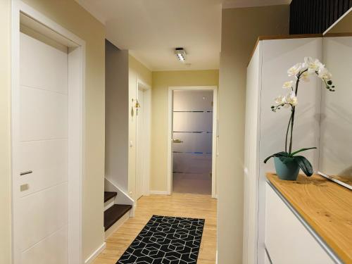 a hallway with white cabinets and a vase with flowers at 8 Personen Ferienhaus ,,Seegelblick" am Goitzschesee, erste Reihe am Strand mit Sauna, Kamin, Wallbox & SUP in Pouch