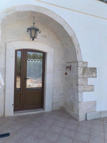 an archway with a wooden door in a house at Vittò in Martina Franca